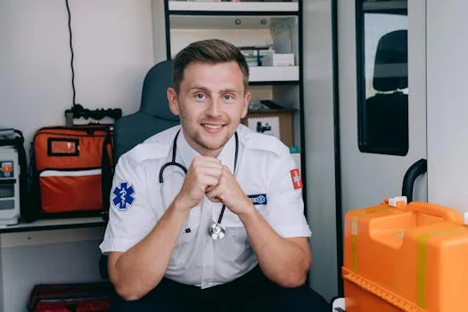 Smiling paramedic in uniform with stethoscope inside ambulance. Healthcare and emergency services concept.