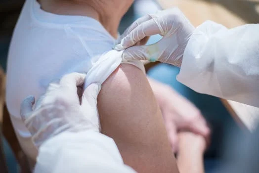 Close-up of a healthcare worker administering a vaccination to a patient in Portugal.